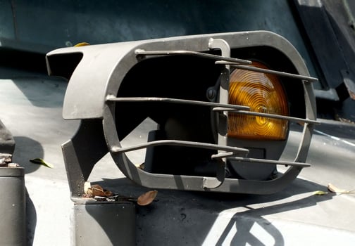 A black light with yellow and orange lights is on the ground. The light is surrounded by a metal frame photo