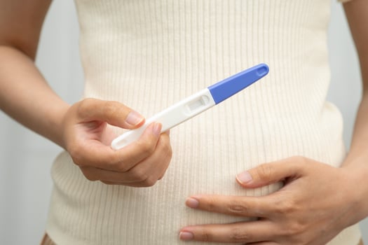 Asian holding pregnancy test for female of ovulation day, fetus, maternity, childbirth, birth control. photo