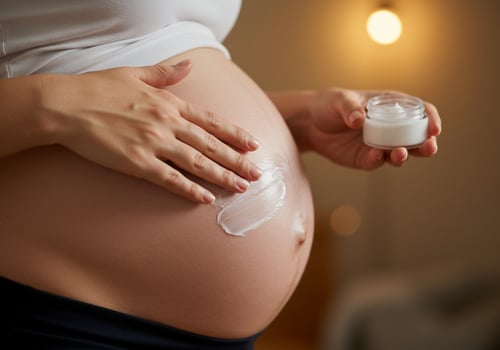 Pregnant woman applying lotion on belly in bedroom at home, maternity skin care photo