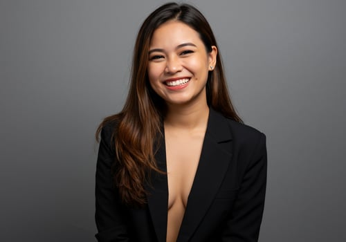 Smiling Asian woman in business attire poses against a solid background photo