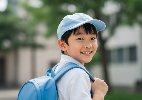 Smiling young student with backpack goes to school on outdoor blurry background photo