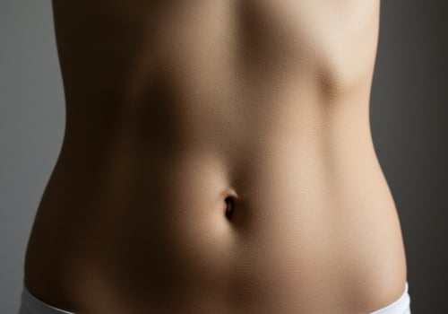 Torso health. Female stomach near a gray background. Showing midriff figure photo