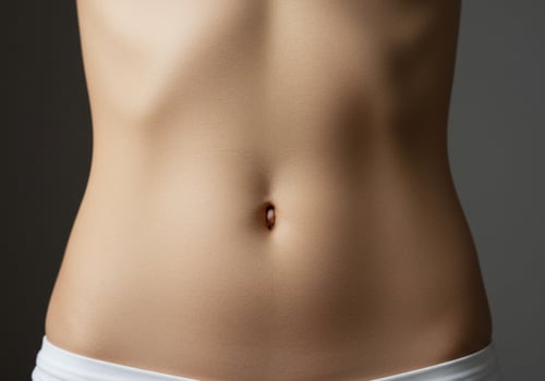 Torso close-up shot, female midriff on grey background, representing health and wellness photo