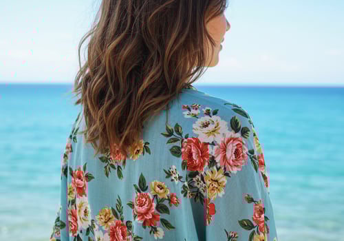 The back of a woman wearing a floral shirt by the ocean photo