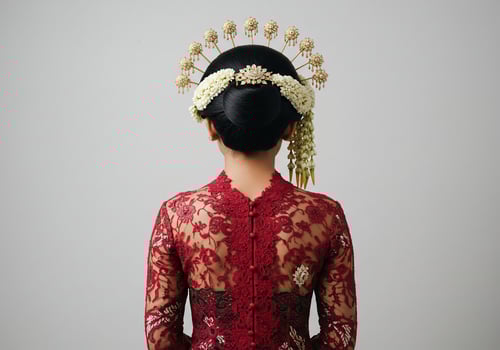 Woman in traditional dress for Javanese ceremony, back view. Plain backdrop photo