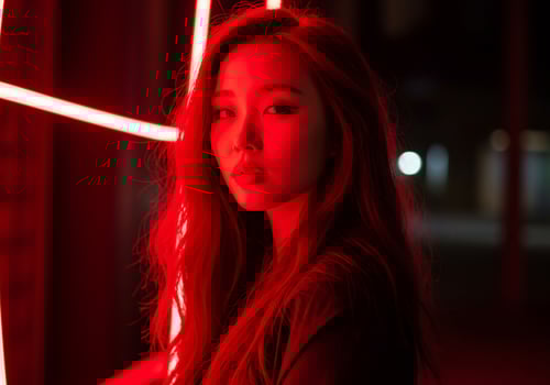 Woman posing illuminated by red light installation at night for a music photo