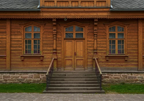 Wooden building facade door entrance and windows under roof and stone basement photo