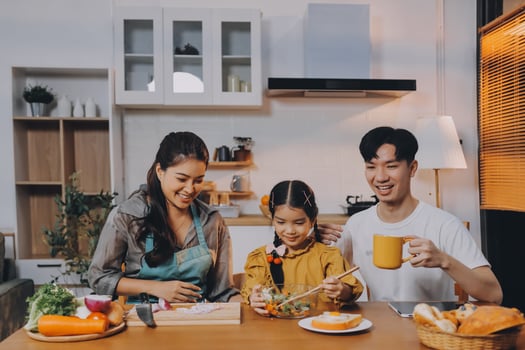 Asian family eating dinner together in kitchen photo