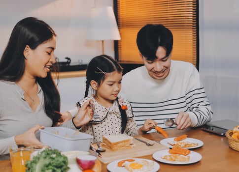A family eating breakfast together at the table photo