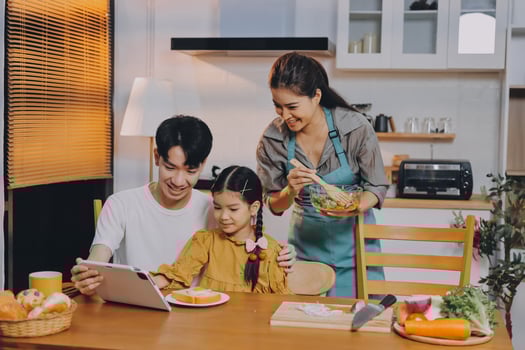 A family sitting at the table with a tablet photo