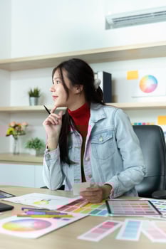 Young Female Designer Pondering Color Choices in Bright Office photo