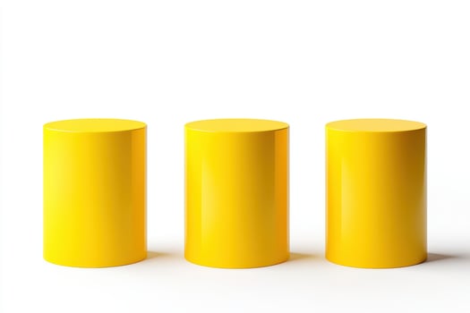 Three bright yellow cylinders of varying heights isolated on white background photo