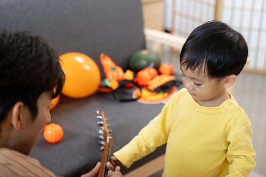 Creative Play. Father and son engaging with Halloween decorations and guitar. photo