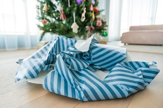 Torn Christmas wrapping paper mess near tree symbolizing holiday excess and paper overuse photo