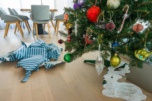 Torn gift wrap near plastic Christmas tree raises questions about holiday waste and sustainability photo