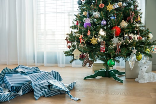 Christmas tree and excessive used gift wrap on floor - symbol of holiday consumerism and paper waste photo