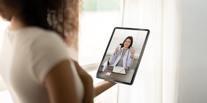 Telemedicine Session. Patient holding tablet during virtual consultation with doctor. photo