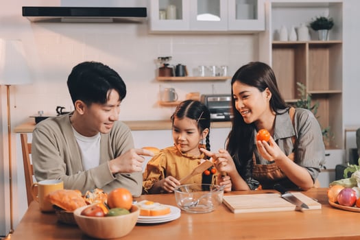 Asian family eating orange in kitchen photo