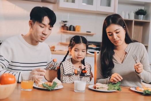A family eating dinner together in the kitchen photo