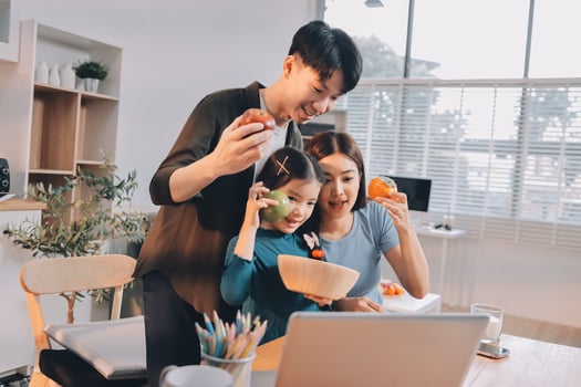 A family eating an apple while looking at a laptop photo