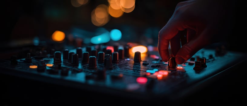 The hand adjusting the mixer amidst colorful lights in a music studio. photo