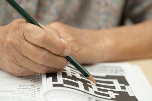 elderly woman playing sudoku puzzle photo