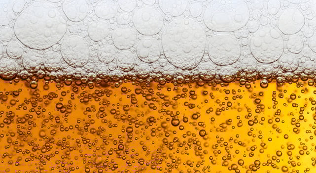 Close-up of dark beer in a glass, showcasing effervescent bubbles and creamy foam. A banner template for Oktoberfest, Beer Day, or fresh drink ads ample space for your text. photo