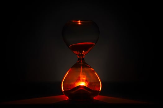 artistic glowing hourglass like sunrise or sunset, symbolizing time and creativity. Vibrant lighting against a dark minimalist backdrop. Concepts of time management, life balance, and artistic design photo