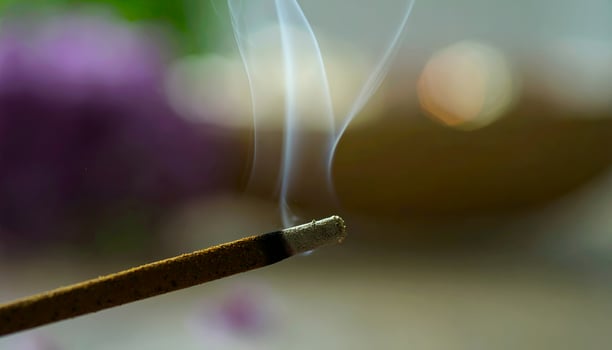 Incense Stick Burning with Smoke Trails on Blurred Background. photo