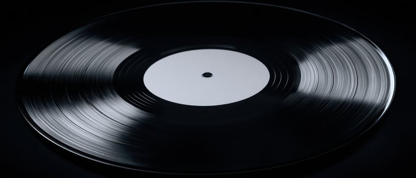 The vinyl record showcasing intricate grooves on a black background. photo