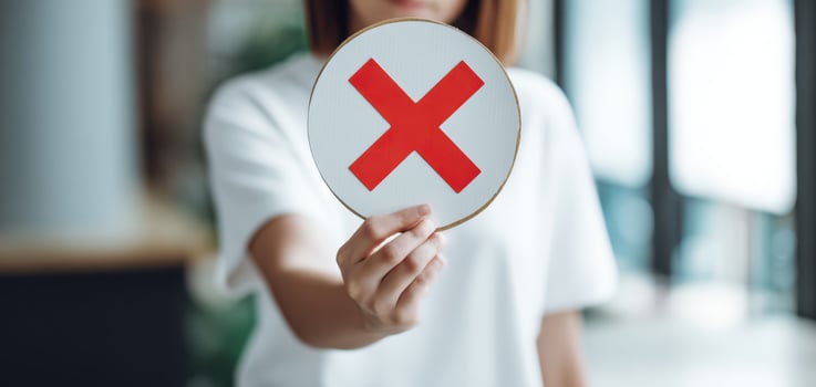 The woman holding a red X sign symbolizing disagreement or rejection in a modern setting. photo