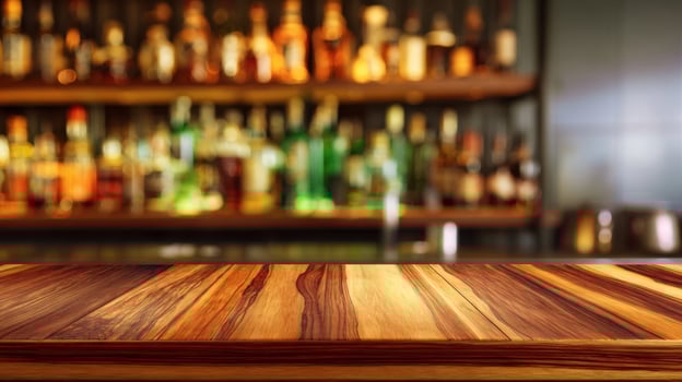 The elegant wooden bar counter with blurred bottles in the background. photo