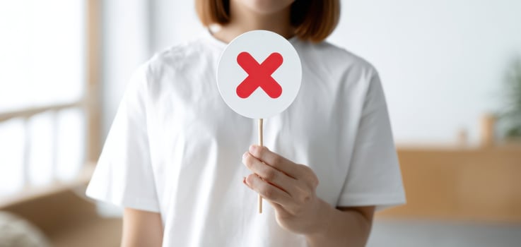 The woman holding a sign displaying a red 'X' symbol of rejection. photo