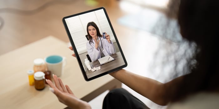Telemedicine Interaction. Doctor discussing medication with patient via tablet. photo