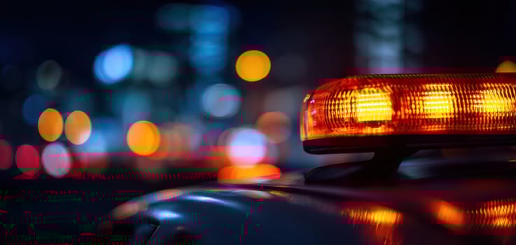 The illuminated police vehicle light shining brightly in a nighttime urban setting. photo