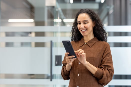 Woman with smartphone in office setting photo