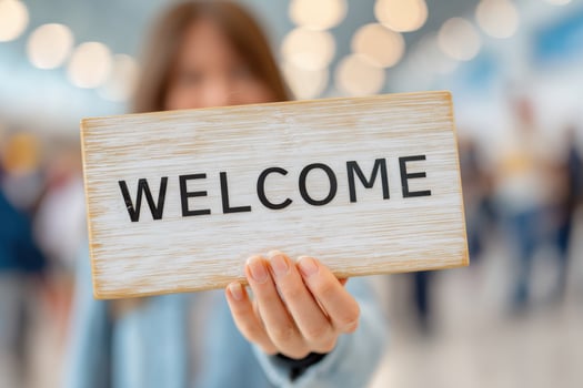 Woman holding welcome sign in airport or train station photo
