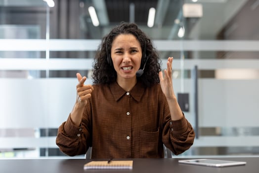 Frustrated woman in office with headset photo