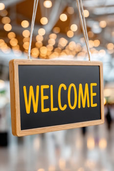Welcome sign hanging in a commercial space with warm lighting photo