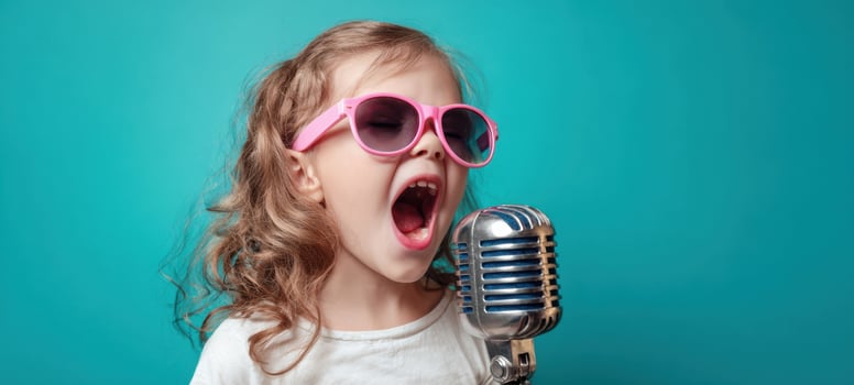 The energetic girl singing into a vintage microphone with stylish sunglasses. photo