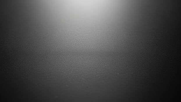Black and white photo of a dark room with a light coming from the ceiling