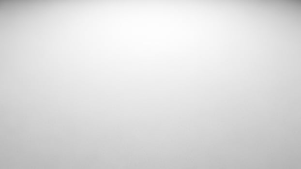 A black and white photo of a person standing in front of a white wall