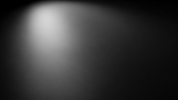 a sl a ck a nd white photo of a light shining on a w a ll