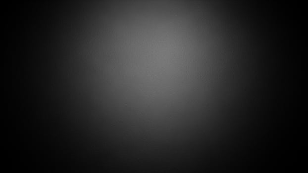 Black and white photo of a person standing in front of a black background