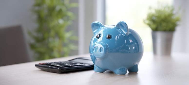 The blue piggy bank next to a calculator on a modern workspace. photo