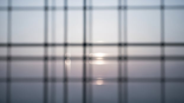 A blurry photo of a window with a sun setting behind it