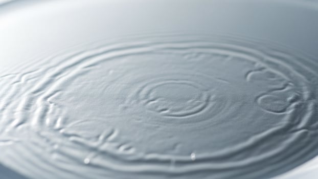 A circular pattern of water ripples on a white surface photo