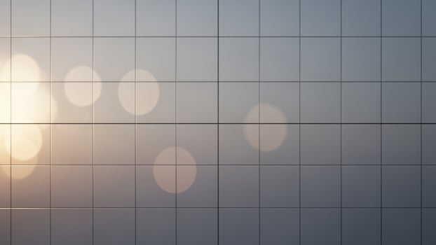 A man is standing in front of a wall with a grid of squares photo
