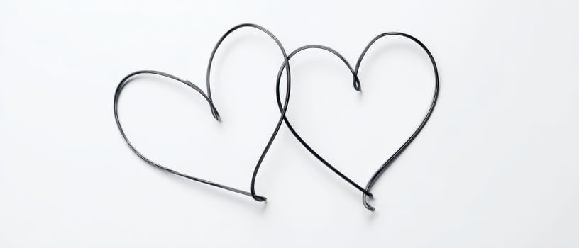 The intertwined wire hearts symbolize love and connection in minimalist design. photo