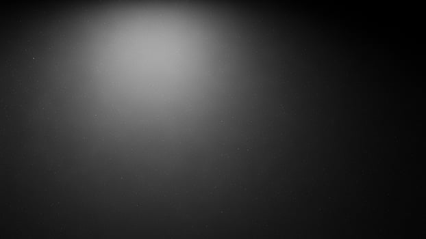 A black and white photo of a person standing in the dark